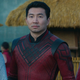 Meng’er Zhang, Simu Liu, and Awkwafina are all staring in the same direction while standing side by side Shang-Chi and the Legend of the Ten Rings.